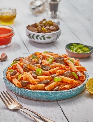 Side view of a plate of pasta with liver and hot pepper