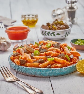 Side view of a dining table containing pasta with liver and appetizers