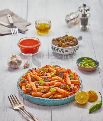 Top view of a dining table containing pasta with liver and appetizers