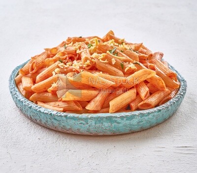Side view of a plate of pasta in a solid background