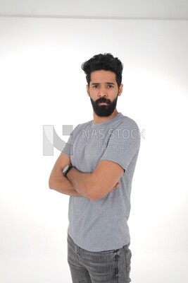 close-up of a Saudi man looking angry, wearing casual clothes, carrying his mobile phone, Saudi model, white background