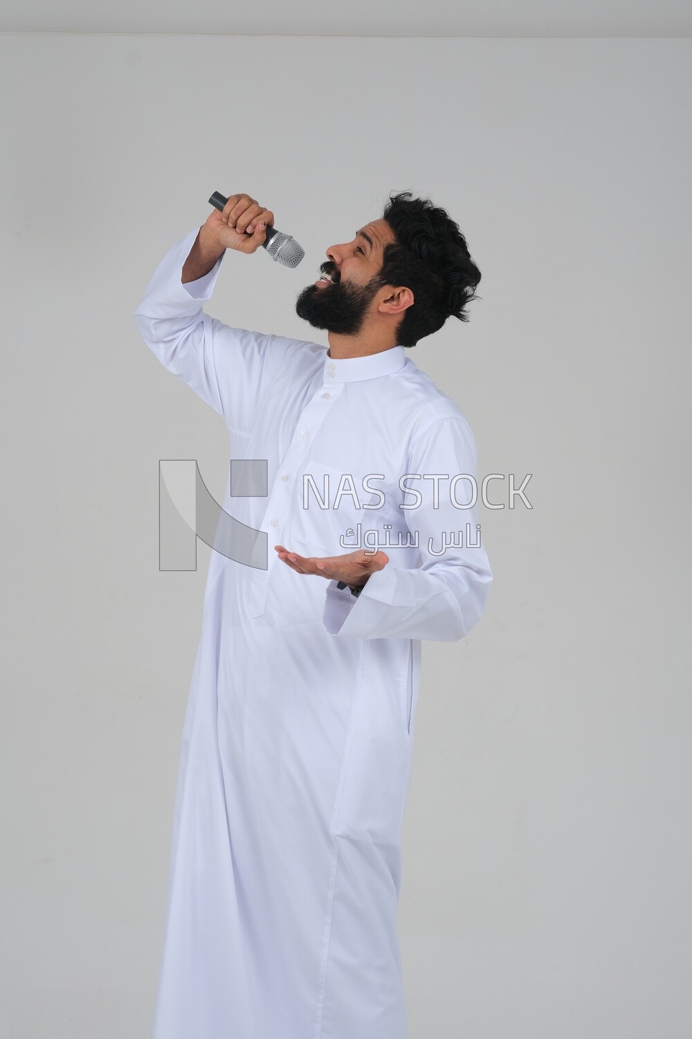 Saudi man in traditional dress holding the microphone, performing theatrical performances, giving speeches, dialogues and discussions, representative performance, lyrical theatrical art, white backgro