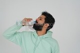 Saudi man wearing casual clothes, drinking from a water bottle, Saudi model, white background