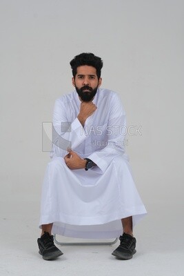 close-up of a Saudi man in traditional Saudi dress, sitting on a chair, Saudi model, white background