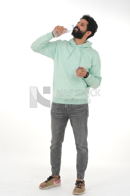 Saudi man wearing casual clothes, drinking from a water bottle, Saudi model, white background