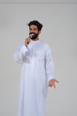 Saudi man in traditional dress holding the microphone, performing theatrical performances, giving speeches, dialogues and discussions, representative performance, lyrical theatrical art, white backgro