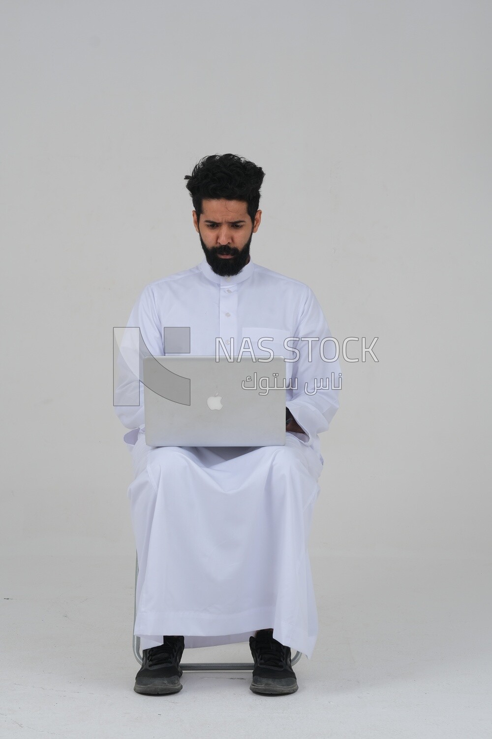 Saudi man sitting in front of a laptop, business feasibility study, white background, Saudi model