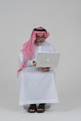 old Saudi man sitting in front of a laptop, business feasibility study, white background, Saudi model