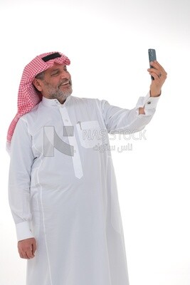 old saudi man using a mobile phone, communicating with individuals, online requests and marketing, social relations, using technical devices, white background
