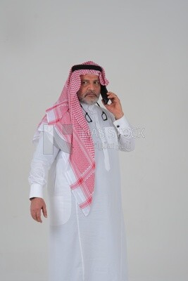 old saudi man using a mobile phone, communicating with individuals, online requests and marketing, social relations, using technical devices, white background