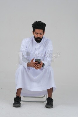 saudi man using a mobile phone, communicating with individuals, online requests and marketing, social relations, using technical devices, white background