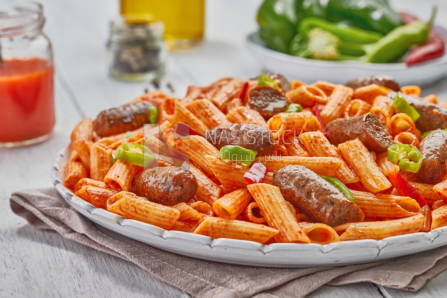Side view of a plate of pasta with sausage and appetizers