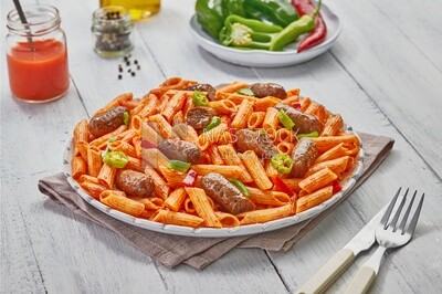 Top view of plate of pasta with sausage and appetizers