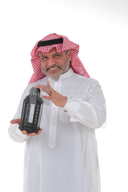 Saudi man holding a Ramadan lantern, Ramadan lantern, the blessed month of Ramadan, lighting and decorations for the month of Ramadan, Ramadan atmosphere, religious occasions