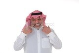 عجوز سعودي يشير بيده على أسنانه ، شاب سعودي يرتدي ثوبا أبيض مع شماغ وعقال ، خلفية بيضاء ، رجل مسن يشير بإصبعه السبابة إلى أسنانه ، مفهوم تعابير الوجه ، موديل سعودى