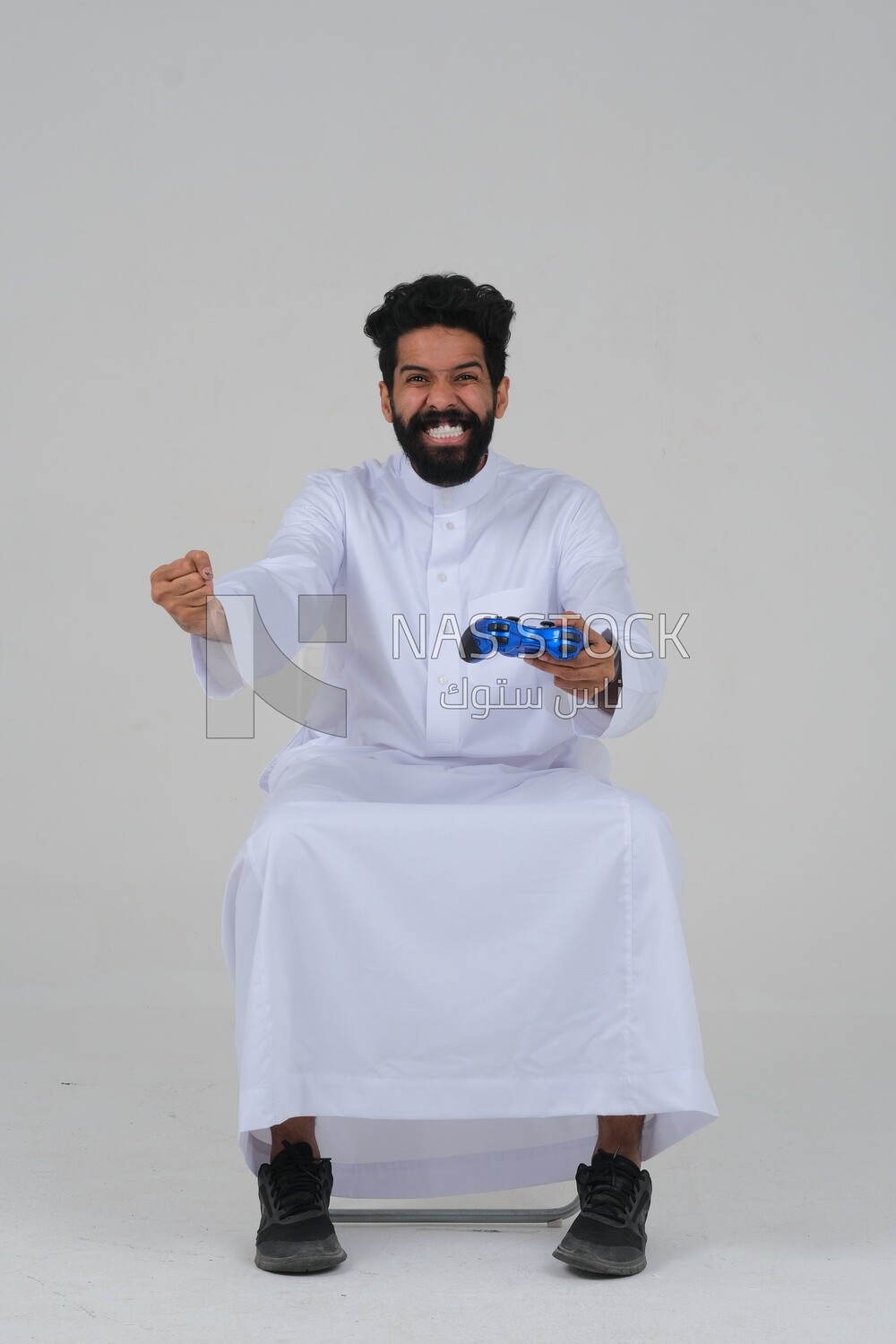 saudi  man holding a joystick in his hand and playing video games, with gestures and expressions that indicate focus and harmony, fun and entertainment with video games, PlayStation entertainment ga