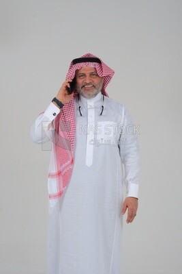 elderly Saudi man using a mobile phone, communicating with individuals, online requests and marketing, social relations, using technical devices, white background