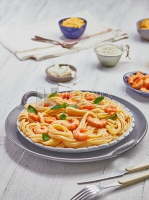 Dining table with shrimp spaghetti and appetizers