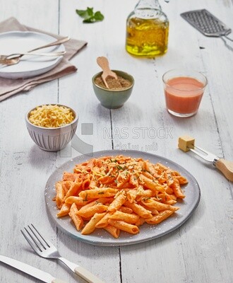 Top view of a dining table with a plate of pasta in red sauce