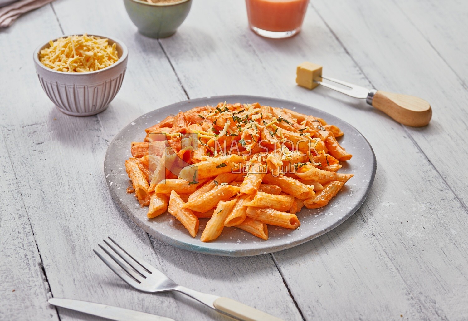 Top view of a dining table with a plate of pasta in red sauce