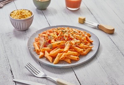 Top view of a dining table with a plate of pasta in red sauce
