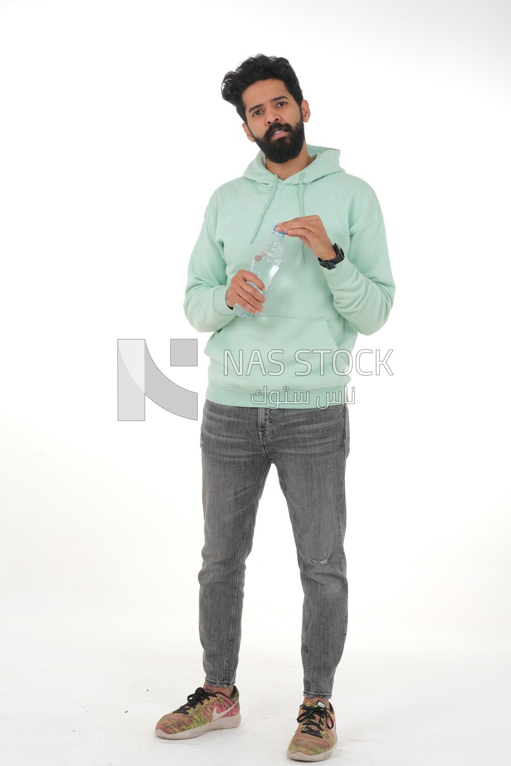 Saudi man wearing casual clothes, drinking from a water bottle, Saudi model, white background
