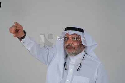 close-up of a Saudi man in traditional Saudi dress pointing away, side view, Saudi model, white background
