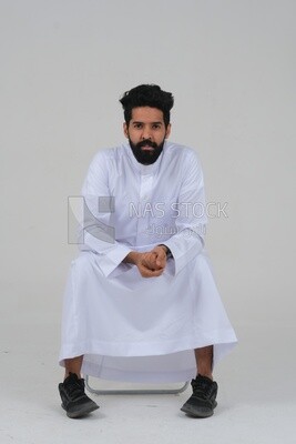 close-up of a Saudi man in traditional Saudi dress, sitting on a chair, Saudi model, white background