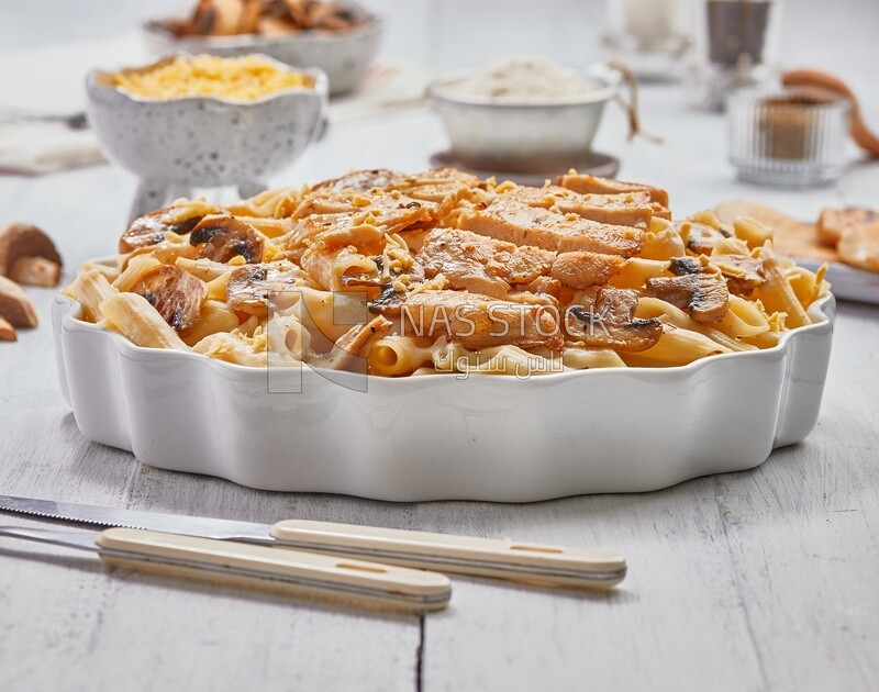 Side view of a plate of pasta with mushrooms and chicks