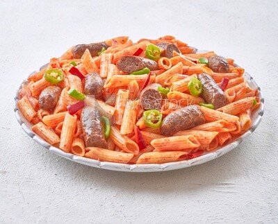 Plate of pasta with sausage in a solid background