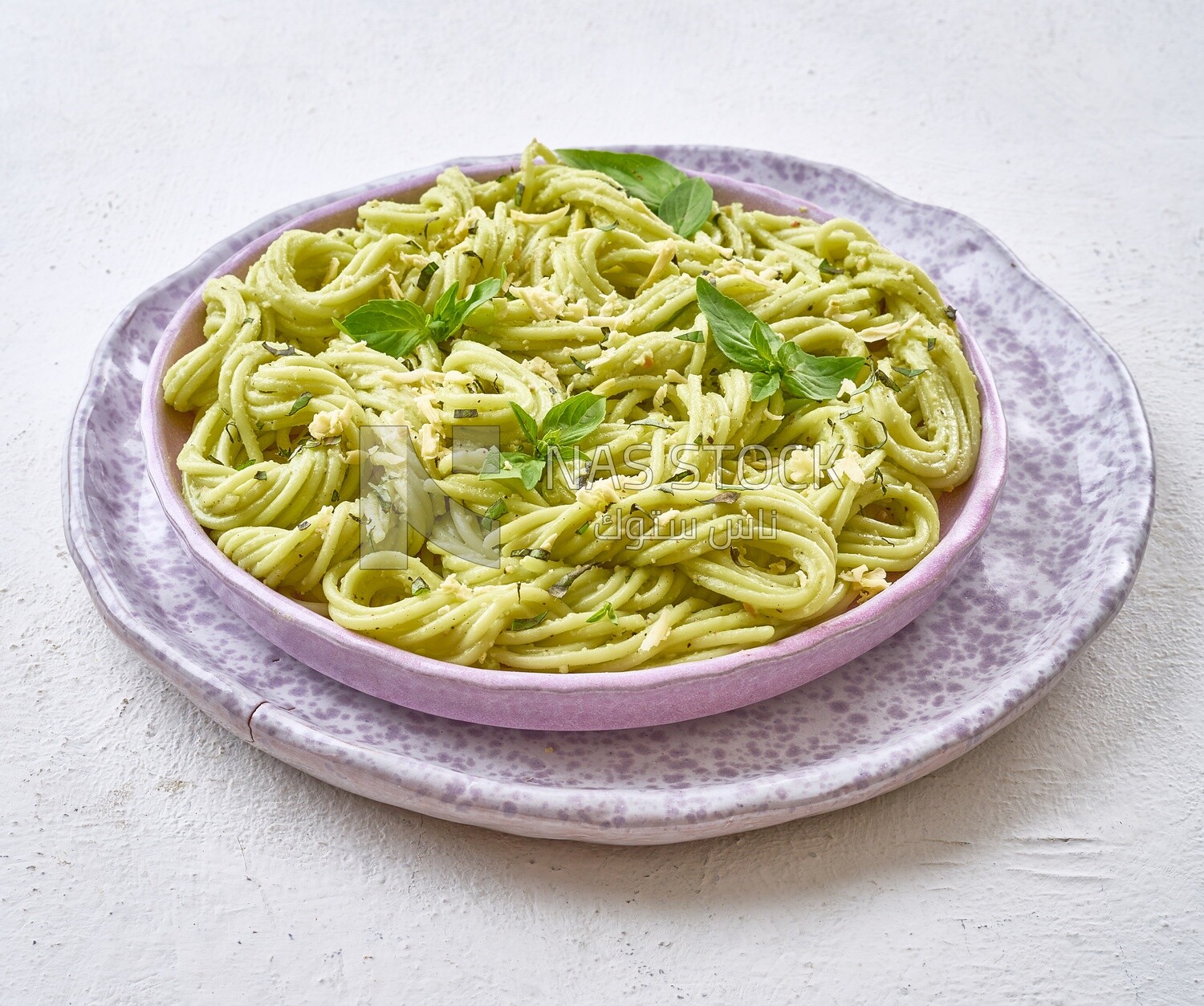 Pesto pasta with basil on a solid background