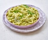 Pesto pasta with basil on a solid background