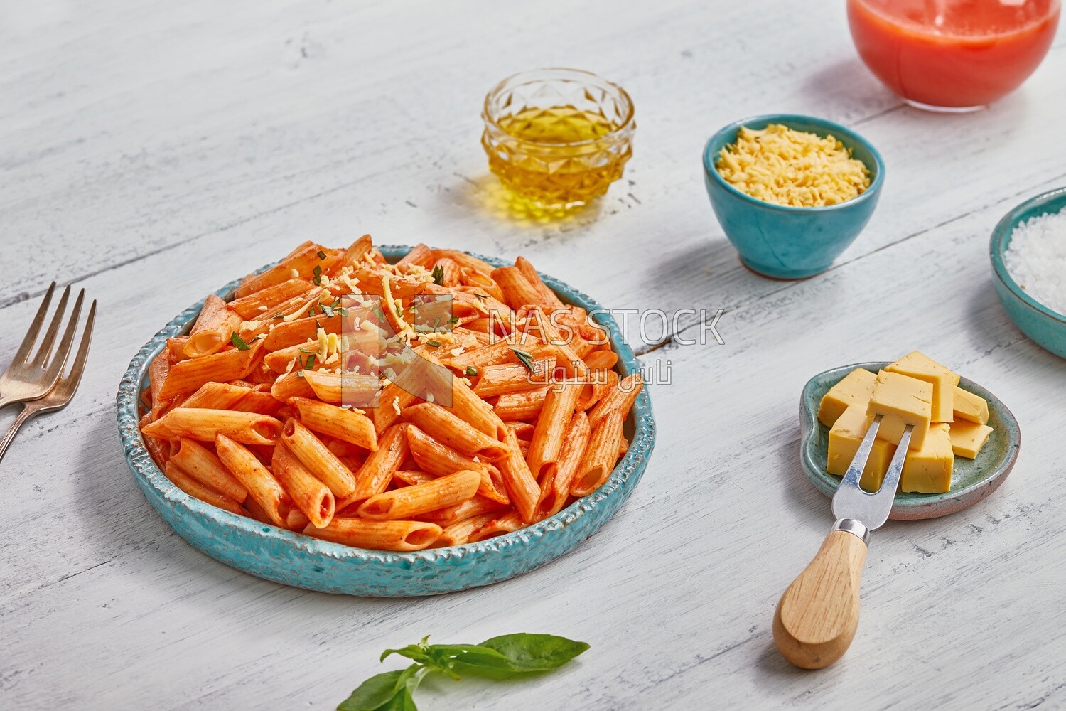 Dining table with a plate of pasta in red sauce and appetizers