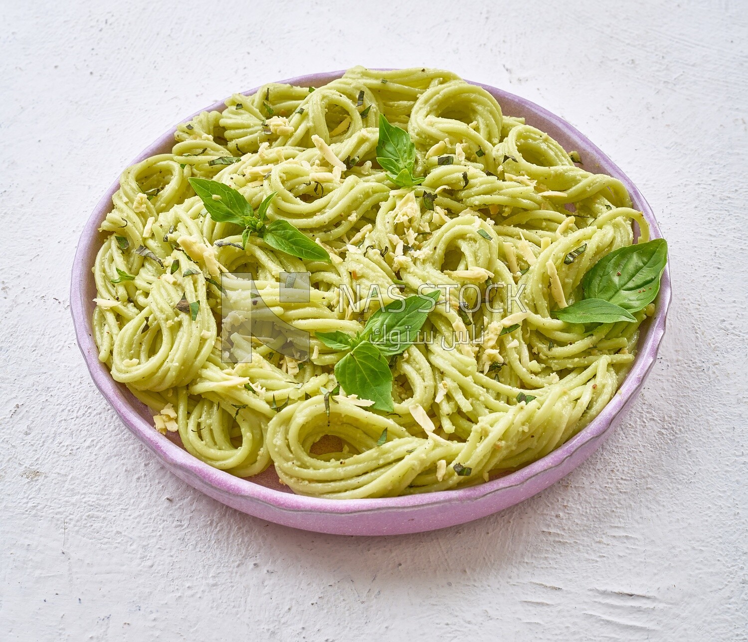 Pesto pasta with basil on a solid background