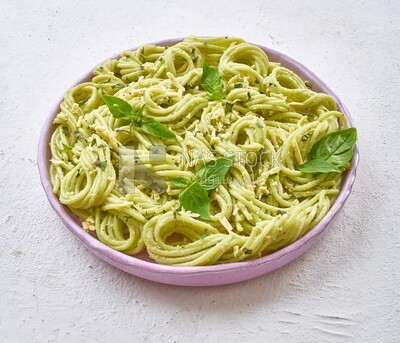 Pesto pasta with basil on a solid background