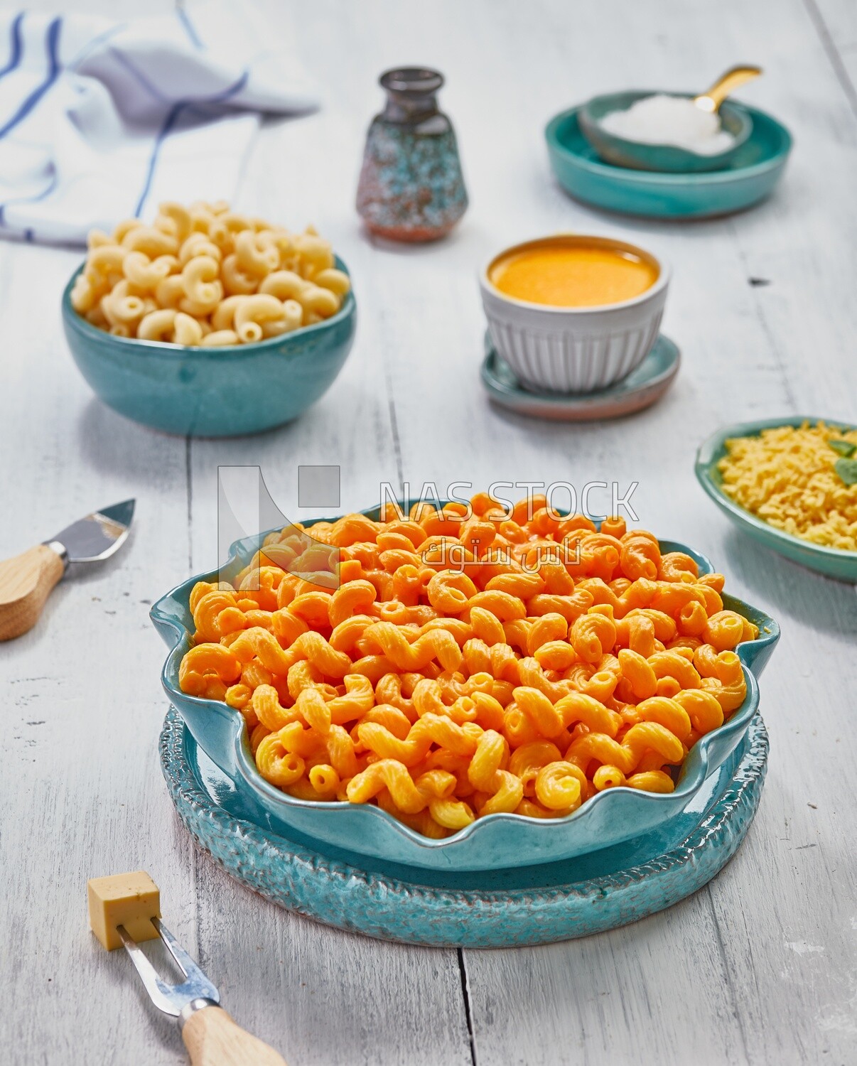 View of a dining table containing a plate of pasta with cheese and appetizers