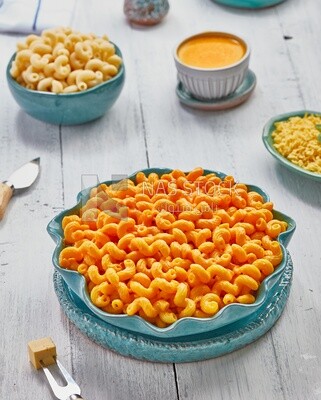 Top view of a dining table containing a plate of pasta with cheese and appetizers
