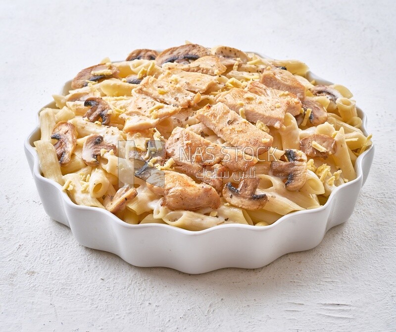 Pasta with mushrooms and chicken on a solid background