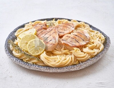 Pasta with chicken and lemon on a solid background