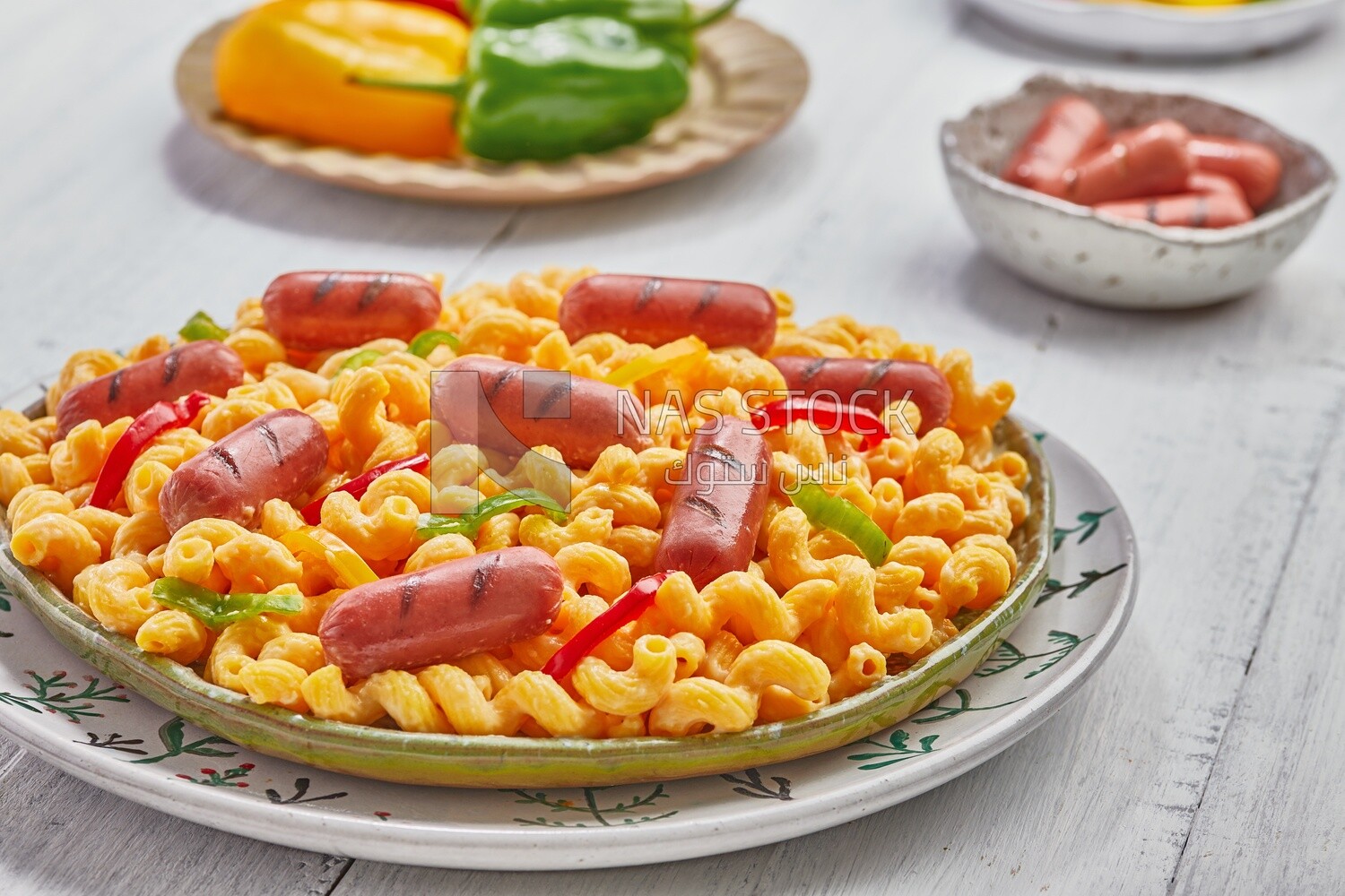 Side view of a plate of pasta with sausage and appetizers