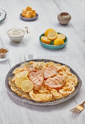 plate of spaghetti with chicken and appetizers
