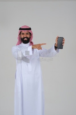 Saudi man using a mobile phone pointing on it, communicating with individuals, online requests and marketing, social relations, using technical devices, white background