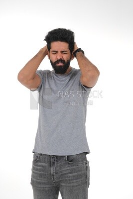 Saudi man wearing a casual dress with his hands on his head, feeling pain and headache, wearing a white dress with a shemagh and headband, white background