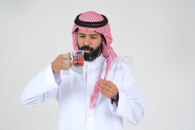 Saudi man wearing a white dress, drinking a cup of tea, self-confidence, white background, Saudi model