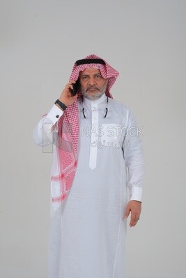 elderly Saudi man using a mobile phone, communicating with individuals, online requests and marketing, social relations, using technical devices, white background