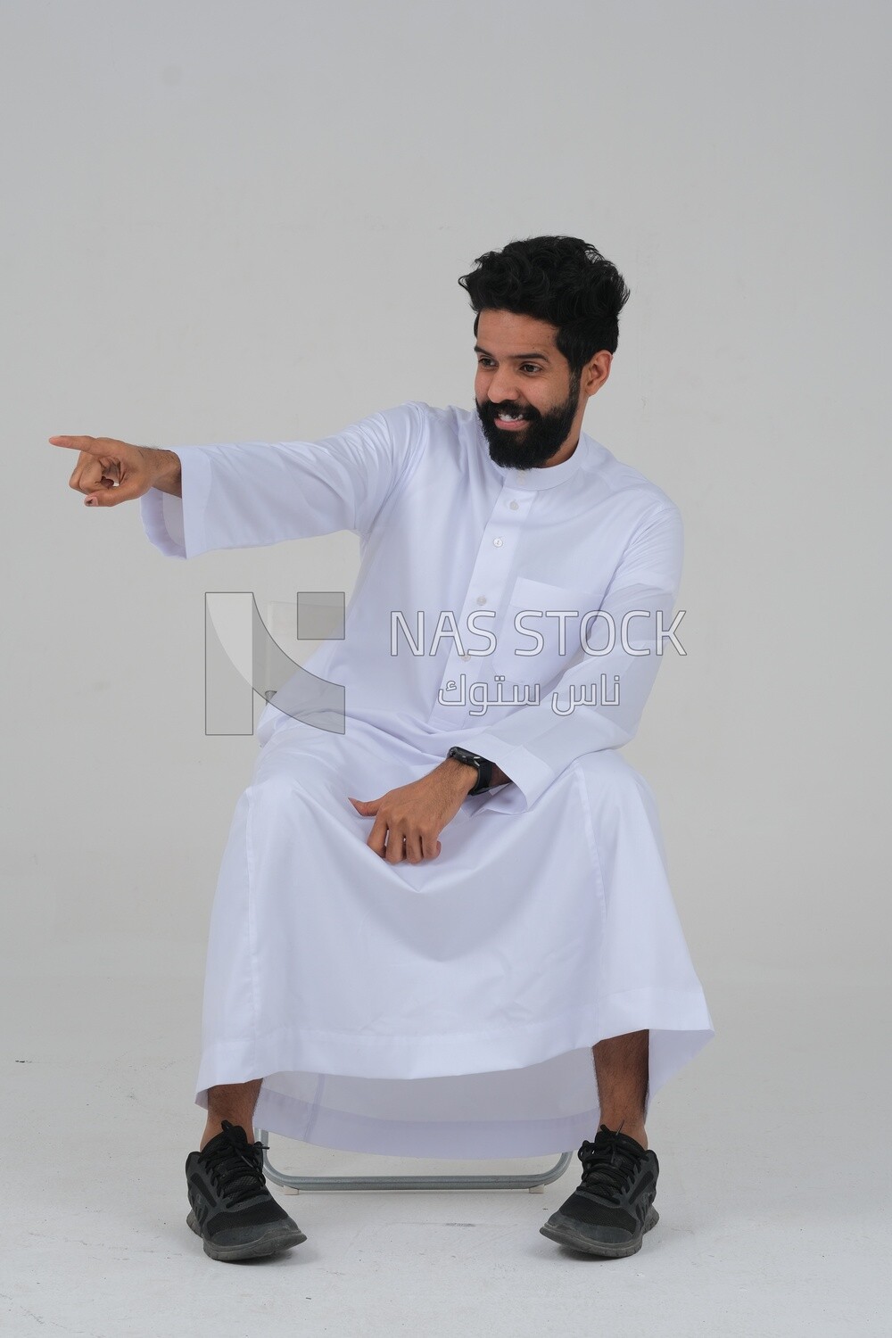 close-up of a Saudi man in traditional Saudi dress pointing away, side view, Saudi model, white background
