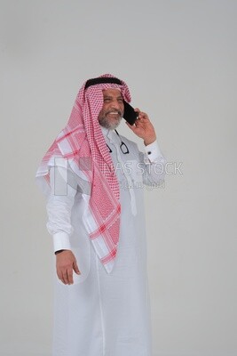 elderly Saudi man using a mobile phone, communicating with individuals, online requests and marketing, social relations, using technical devices, white background