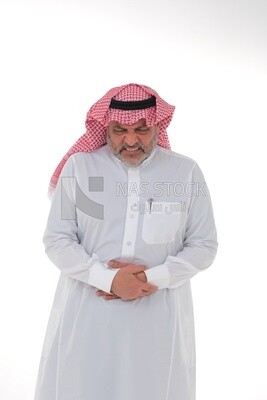 Saudi man placing his hands on his stomach,  abdominal and stomach pain, intestinal disorders, digestive system imbalance, white background