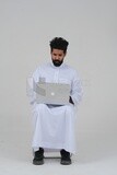 Saudi man sitting in front of a laptop, business feasibility study, white background, Saudi model