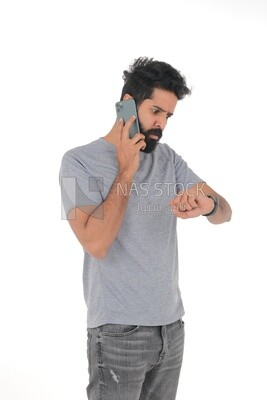 close-up of a Saudi man looking angry, wearing casual clothes, carrying his mobile phone, Saudi model, white background